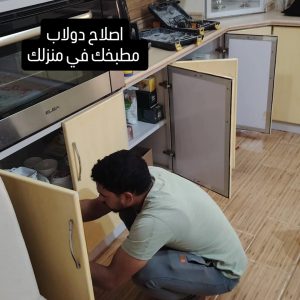 فني يقوم بخدمة صيانة دواليب مطابخ بجدة مع إصلاح الأبواب والمفصلات بشكل دقيق