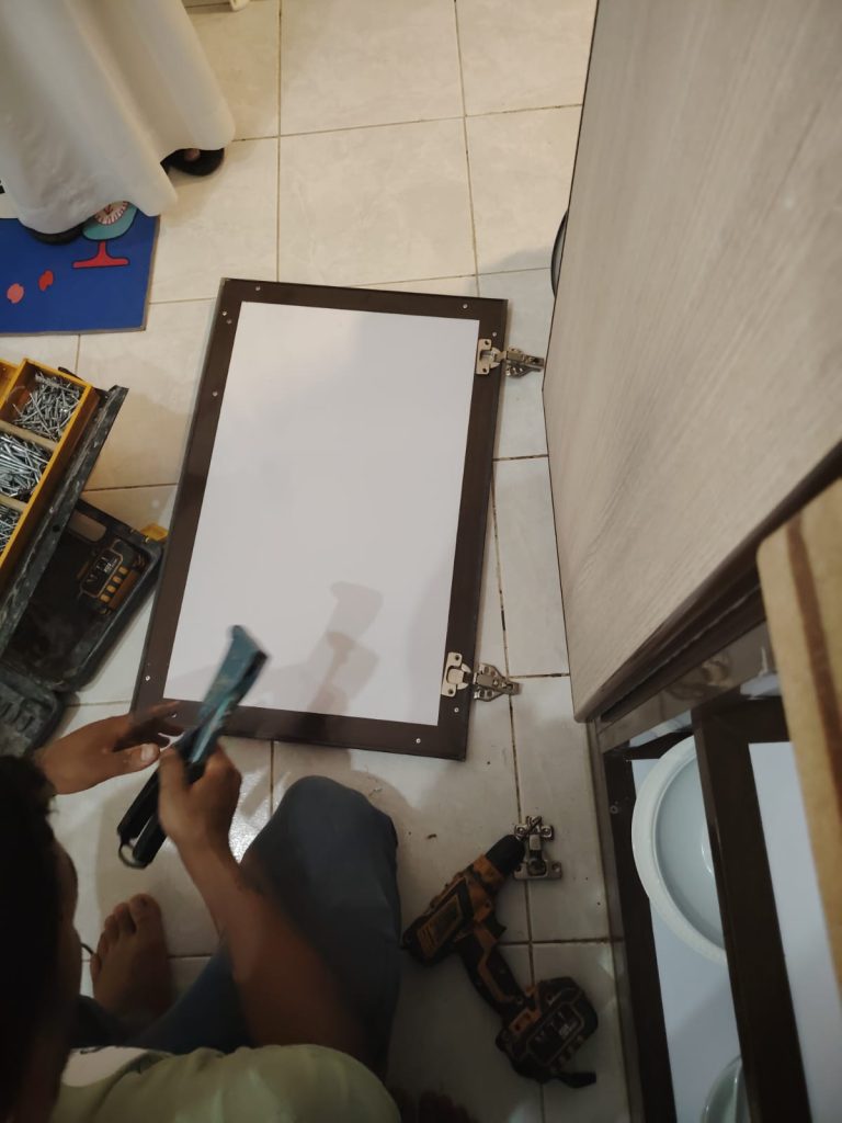 فني متخصص في صيانة دواليب المطبخ في جدة يقوم بإصلاح المفصلات وتعديل الأبواب بدقة