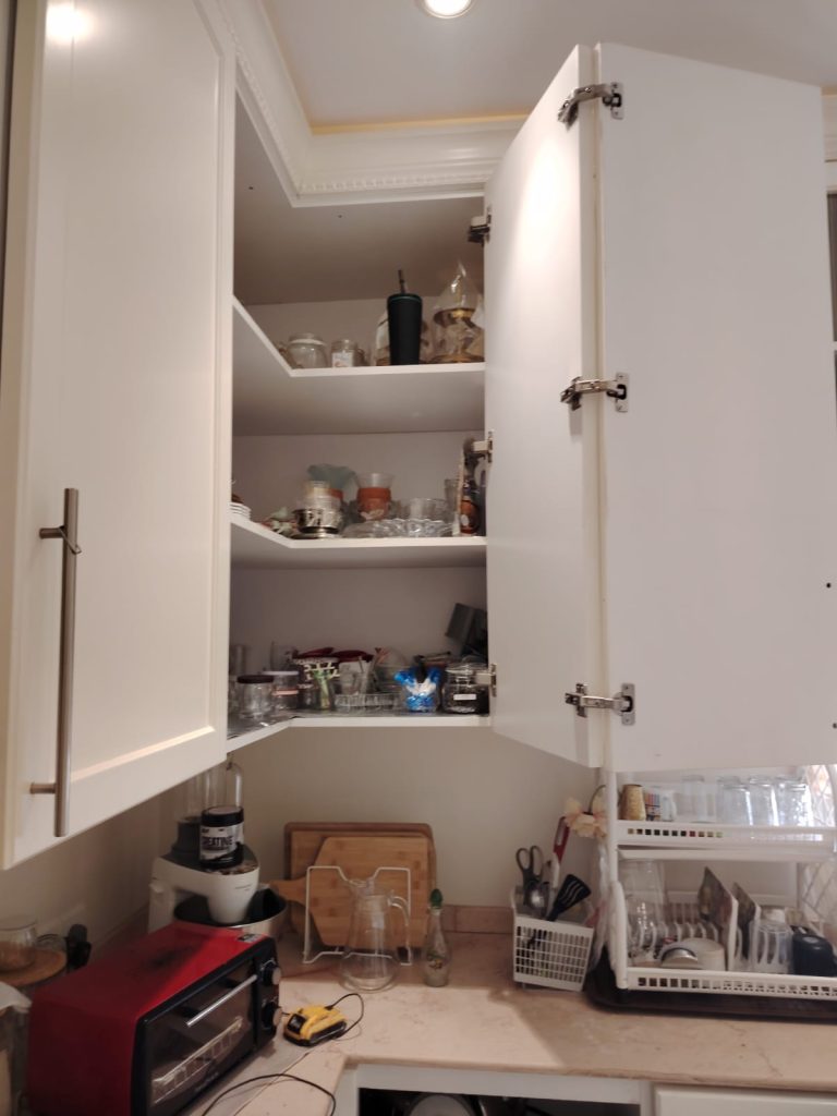 فني متخصص في تصليح مفصلات المطبخ بجدة يقوم بضبط أبواب الخزائن بدقة