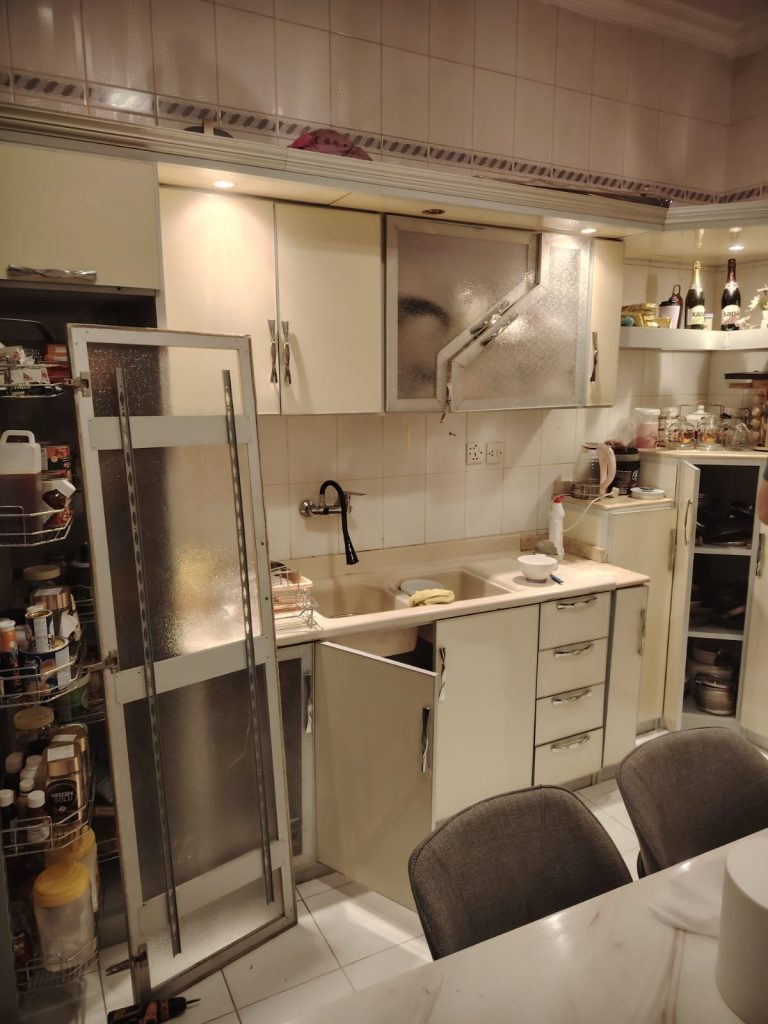 فني يقوم بإصلاح مفصلات المطبخ وضبط أبواب الخزائن لتعمل بسلاسة