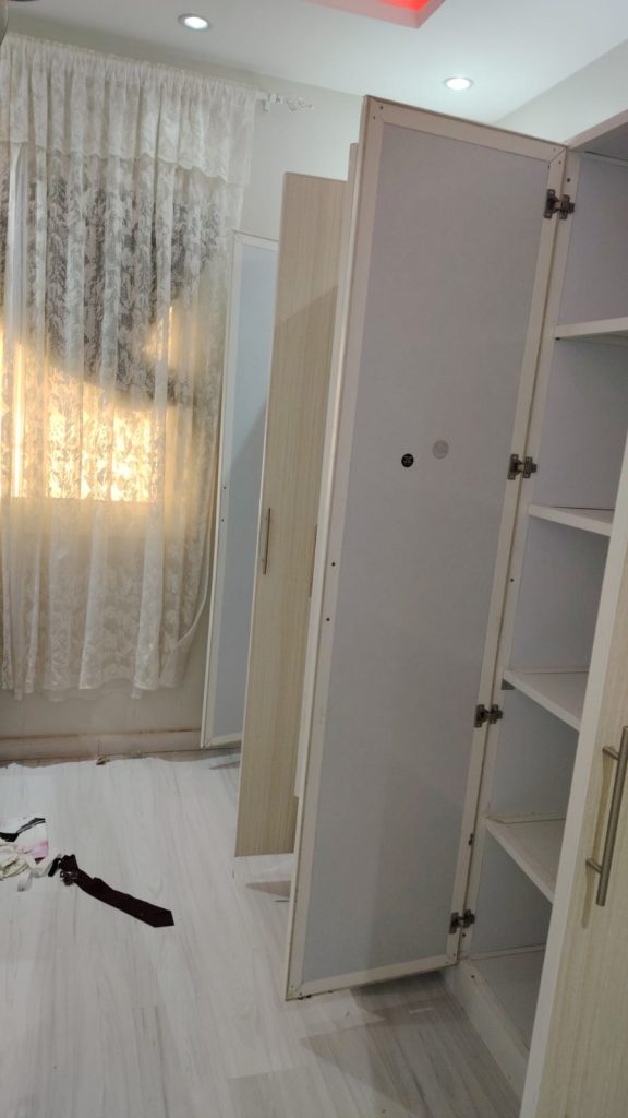 ✅ صورة واقعية لدواليب ألومنيوم طويلة بأبواب مفتوحة توضح المفصلات الداخلية وهيكل التخزين داخل الغرفة بدون ظهور أي عمال.